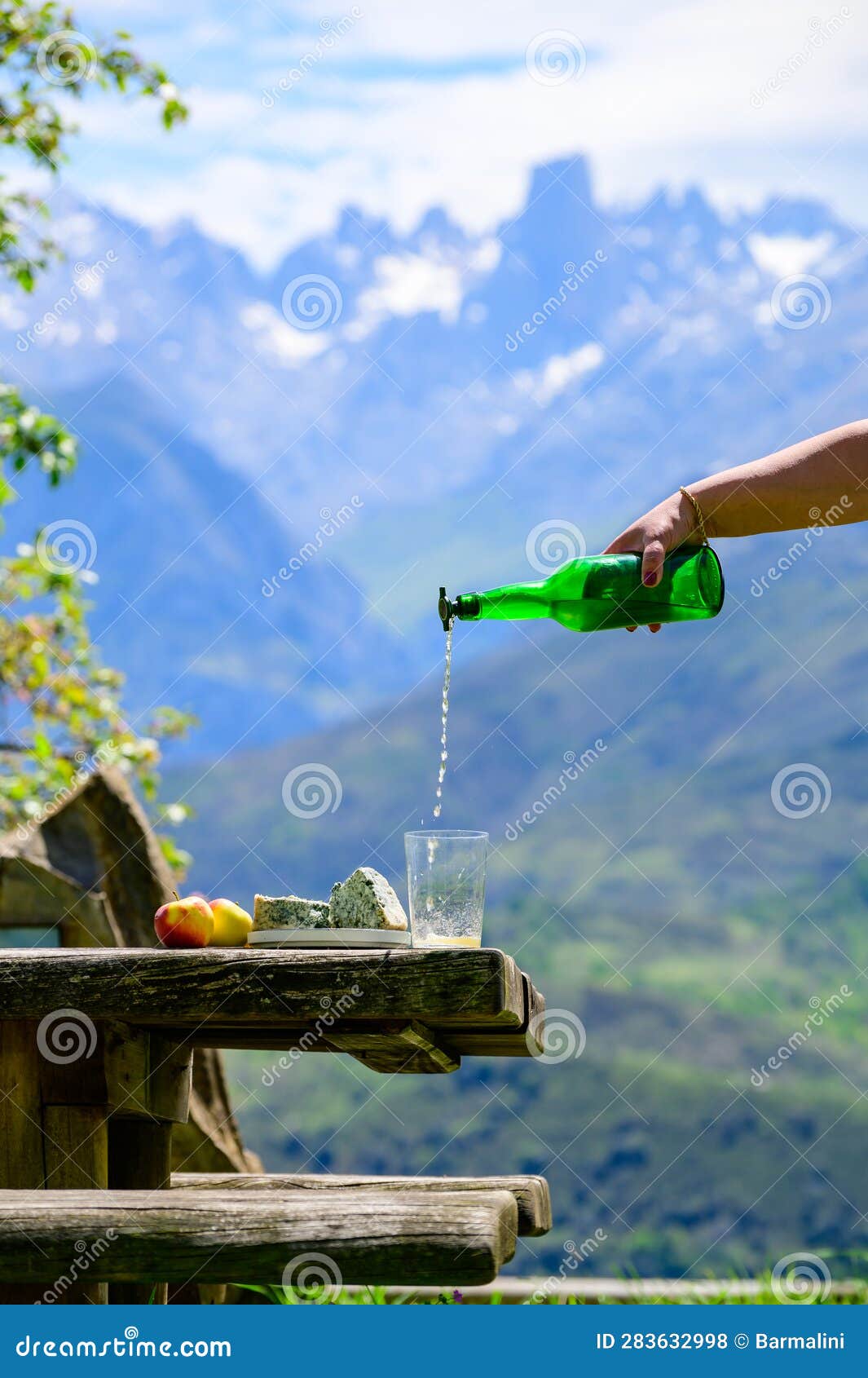 pouring from high height of natural asturian cider made fromÃÂ fermented apples, asturian cabrales cow blue cheese with view on